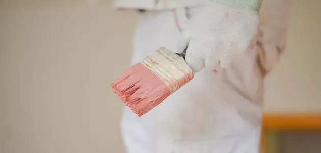 Artisan peintre BL Peinture Rénov tenant un pinceau chargé de peinture, prêt à intervenir au Muy